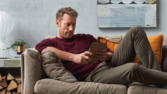 Mand sidder på sofa med sin app fra Electrolux