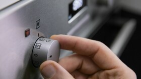 Vand, der hældes i damprummet og PlusSteam-knappen på Electrolux multifunktionsovnen med PlusSteam