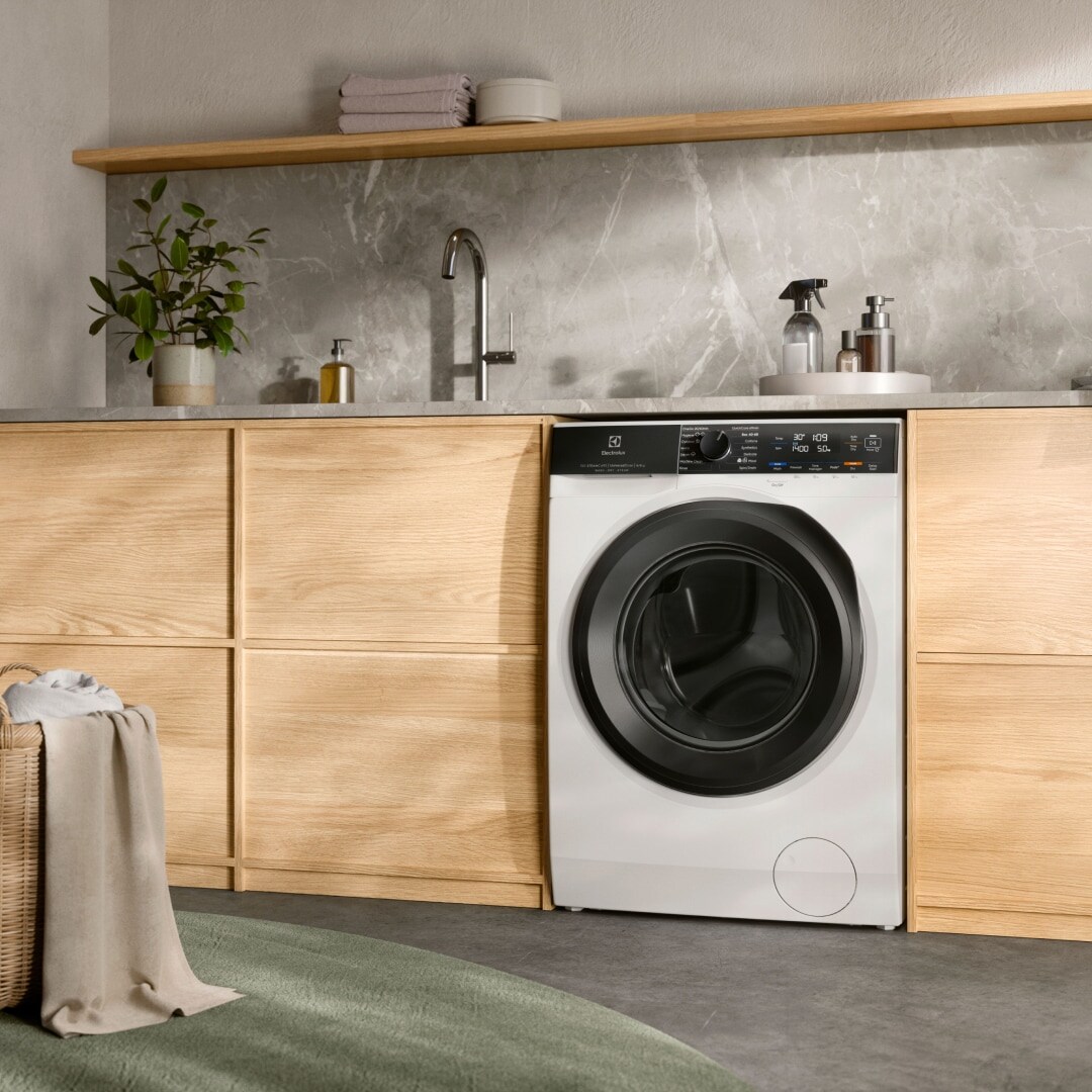 Electrolux vaske-/tørremaskine under et arbejdsbord.