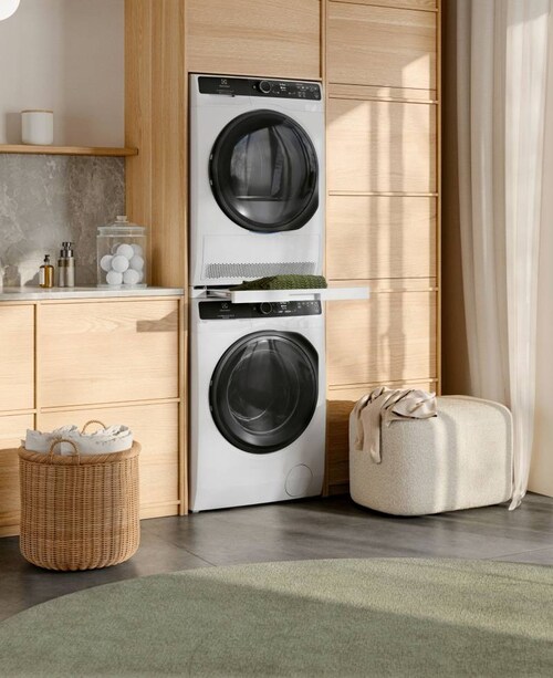 Electrolux tørretumbler og vaskemaskine stablet oven på hinanden i et lokale oplyst af solen.