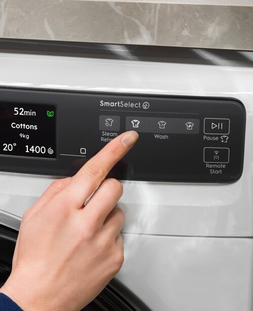 En person justerer indstillingerne på en Electrolux vaskemaskine.