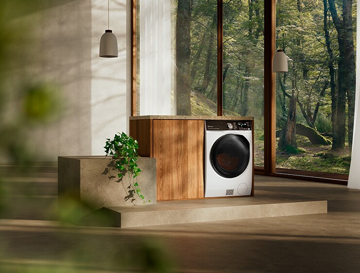 Vaskemaskine i et rum med et stort vindue i baggrunden.