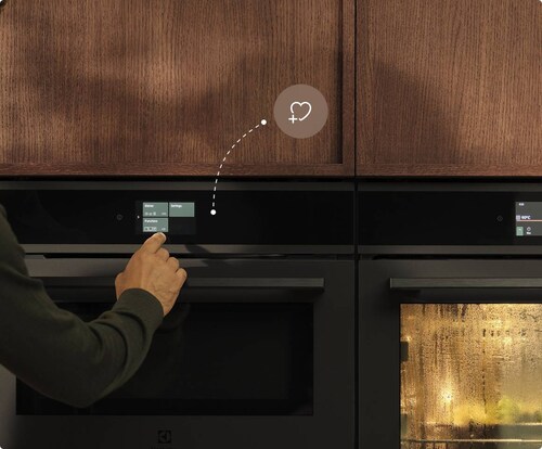 En mand tænder for ovnen i køkkenet.