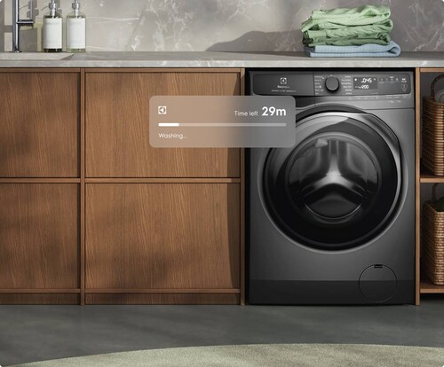 Mørkegrå vaskemaskine i et vaskerum.