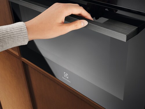 A person opening an oven