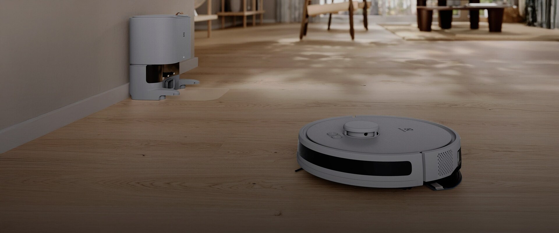 Selvkørende Elctrolux robotstøvsuger som rengør et lyst trægulv i en åben og moderne stue.