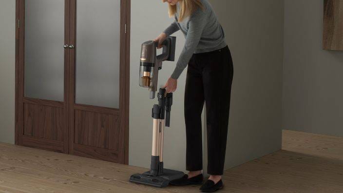 En kvinde forbereder en ledningsfri støvsuger.