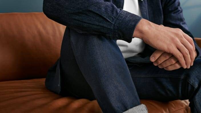 en mand sidder i en sofa